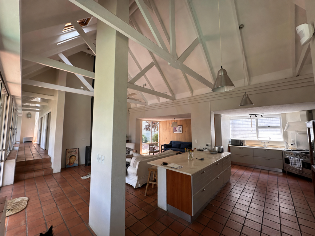 Open-plan living and kitchen with original terracotta tiled floors before renovation, Benmore Gardens