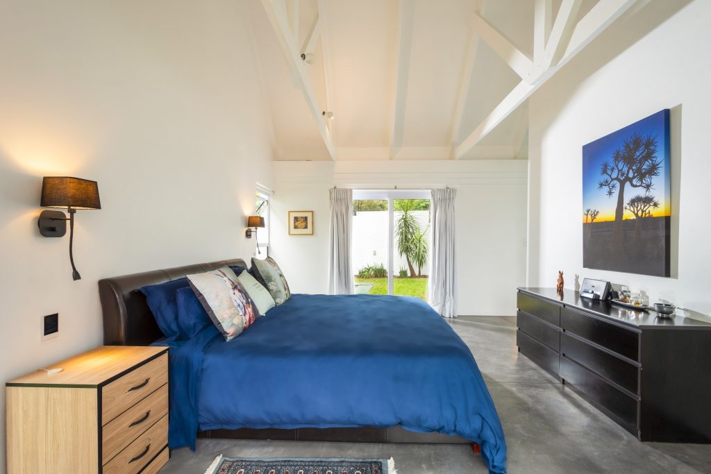 Angus8 Main bedroom with polished concrete floor and garden view, Benmore Gardens