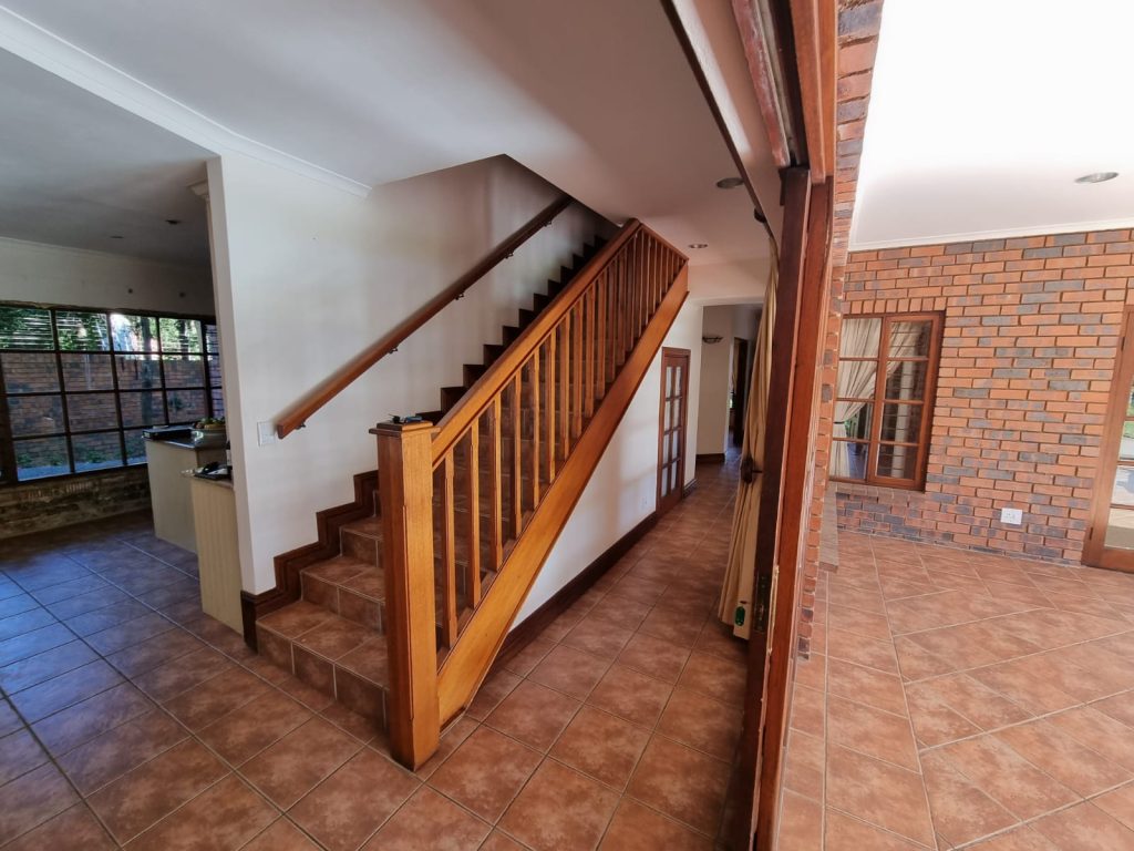 Original timber staircase against exposed brick.
