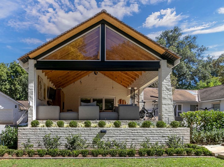 Exterior of the covered patio showing the full gable end with glazed apex and exposed steel beam.